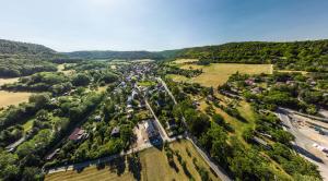 Panoramaluftbild von Ammerbach: Stadtauswärts, der Ortsteil liegt im Tal am Rande von Jena und ist umgeben von grünen Acker- und Waldflächen.