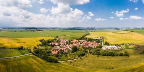 Luftaufnahme von Krippendorf: In der mitte des Bildes liegt die Siedlung mit Häusern, welche umgeben ist von grünen Acker- und landwirtschaftlichen Nutzflächen
