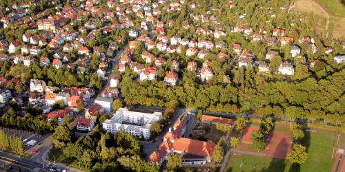 Luftbildaufnahme vom Ortsteil Kernberge: im Vordergrund ist die Schnellstraße gefolgt von der Siedlung mit Häusern mit viel grünen Bäumen dazwischen und auf der rechten Seite ist ein Teil der Kernberge zu sehen