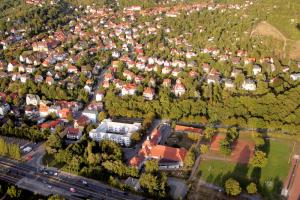 Luftbildaufnahme vom Ortsteil Kernberge: im Vordergrund ist die Schnellstraße gefolgt von der Siedlung mit Häusern mit viel grünen Bäumen dazwischen und auf der rechten Seite ist ein Teil der Kernberge zu sehen