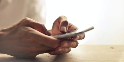 Hände halten Samrtphone und tippen darauf
