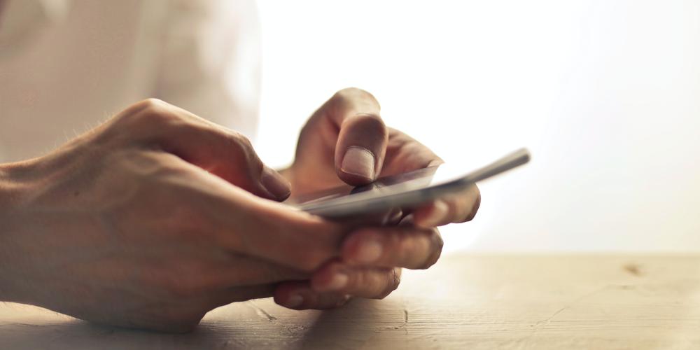 Hände halten Samrtphone und tippen darauf
