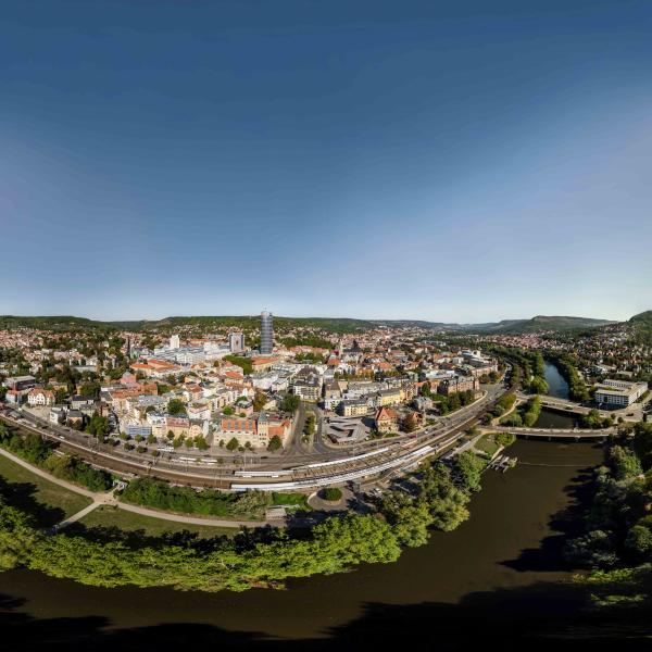 Blick auf eine Stadt, die idyllisch im Grünen und an einem Flussufer gelegen ist